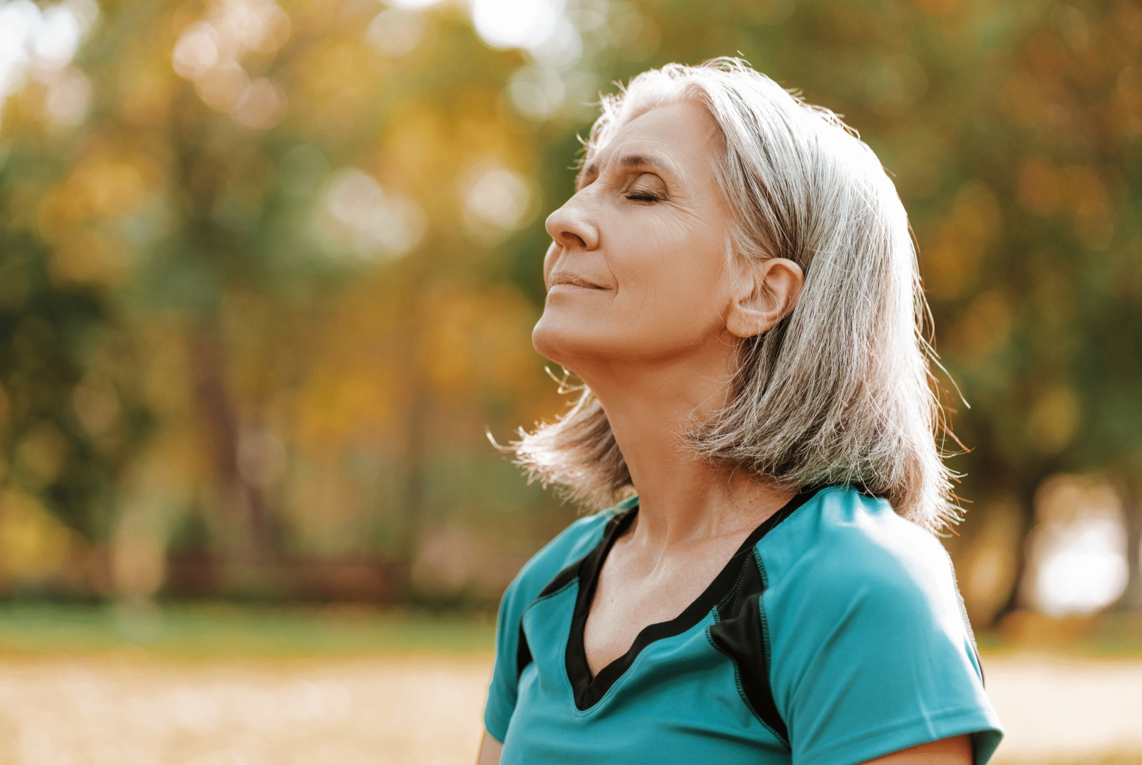 Donna over 50 serena con occhi chiusi al sole - cura e previeni il glaucoma a Milano