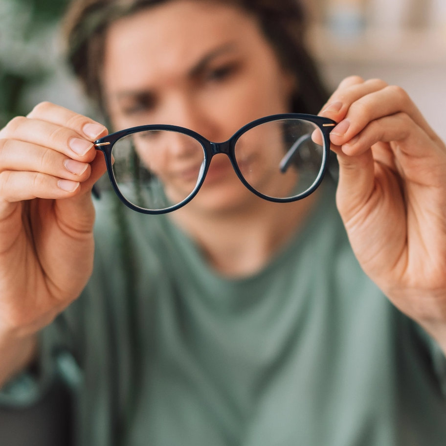 Ragazza che toglie gli occhiali con miopia: i difetti di refrazione eliminati con chirurgia refrattiva a Milano